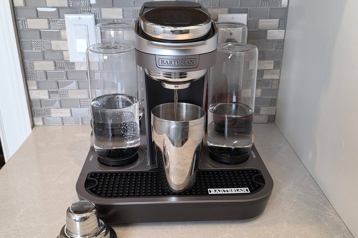 The Bartesian Premier dispensing the 19th Hole cocktail into a stainless steel shaker tin on the bar mat