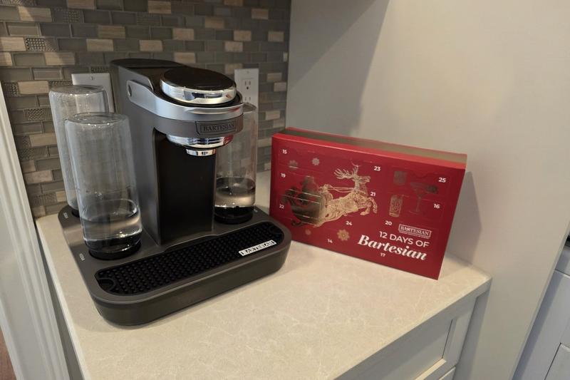 The red Advent Calendar box standing beside a Bartesian cocktail machine on a kitchen counter