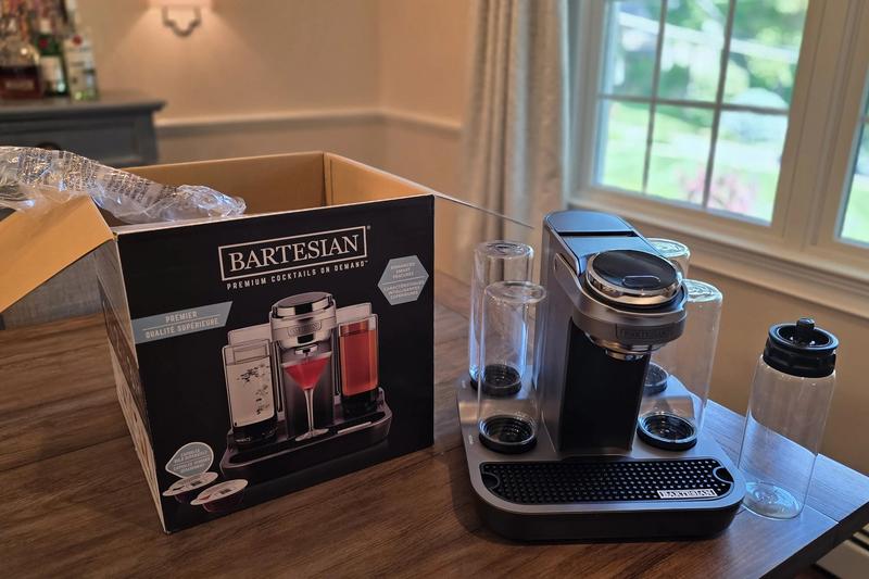 A Bartesian Premier cocktail machine on a dining table beside its open shipping box