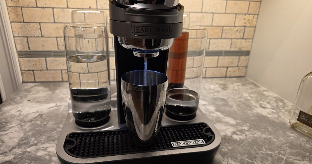 Bartesian Professional cocktail machine actively dispensing into a stainless steel cocktail shaker — blue LED illuminating the chrome, demonstrating the signature 'always shake' technique recommendation.